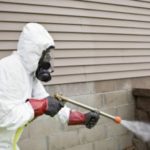 Professional exterminator spraying outside of business in the Mississippi gulf coast; Southern Pest Control
